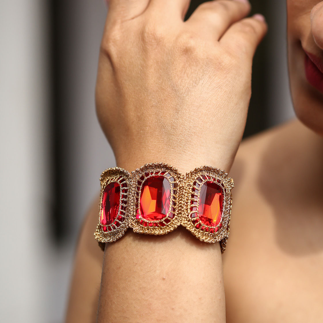 Amelia Crystal Soft Statement Bracelet in red lava colour wrapped around a model's wrist.